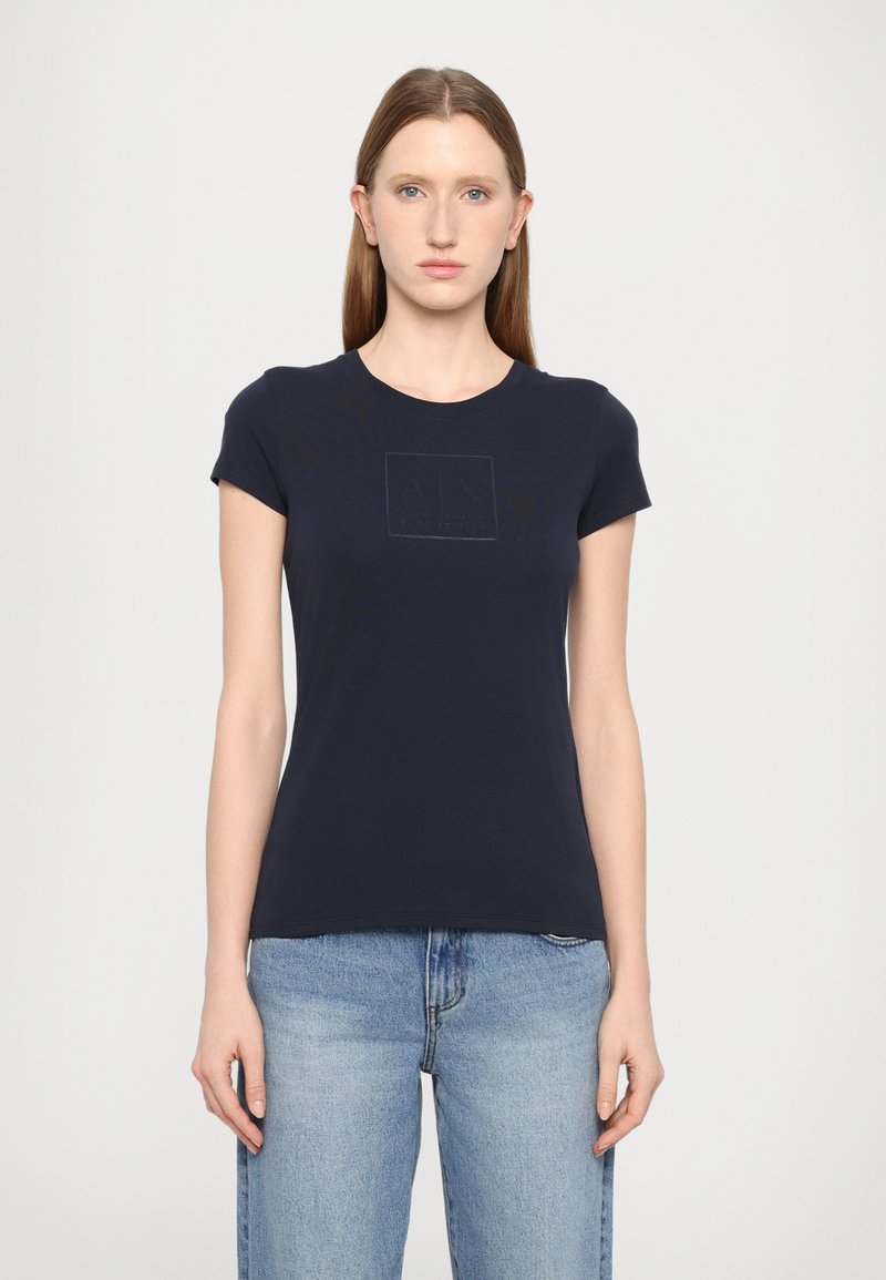 T-shirt in cotone blu navy con maniche corte e colletto rotondo. Presenta un logo quadrato in rilievo discreto sul davanti.