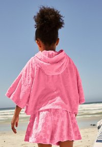 Rosa, mit floralen Mustern bedruckter Frottee-Überwurf mit Kapuze und passenden Shorts, die ein strukturiertes Design und eine lockere Passform aufweisen.