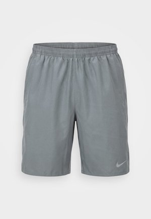 Short de sport gris clair avec taille élastique et poches latérales, avec un petit logo réfléchissant Nike sur la jambe gauche.