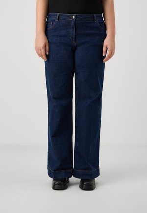 Dark blue, wide-leg denim jeans with subtle stitching details, five pockets, and a mid-rise waist, paired with black shoes.