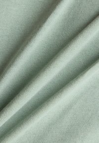Light mint green fabric with a smooth texture and fine ribbing. The material appears soft and slightly stretchy, draping in gentle folds.