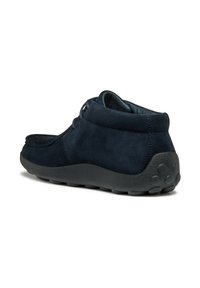 Botas de ante azul marino hasta el tobillo con punta redondeada, suela de goma y acentos de goma redondos. Presentan un cordón de bajo perfil y un forro interior suave.