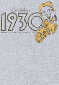 Camiseta gris con un gráfico de un personaje de dibujos animados en una motocicleta, con el texto "Establecido en 1930" y "Propiedad del Club de Motociclistas Biker Betty".