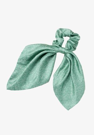 Miętowozielona gumka do włosów z długimi, spiczastymi, luźno zawiązanymi końcami kokardy oraz subtelnym białym wzorem przypominającym rozgałęzienia.