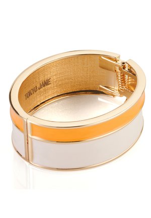 Goldfarbene Armreifen mit weißen, orangen und goldenen Akzenten. Verfügt über eine glatte, glänzende Oberfläche und ein strukturiertes Inneres. Gekennzeichnet mit "Tokyo Jane".