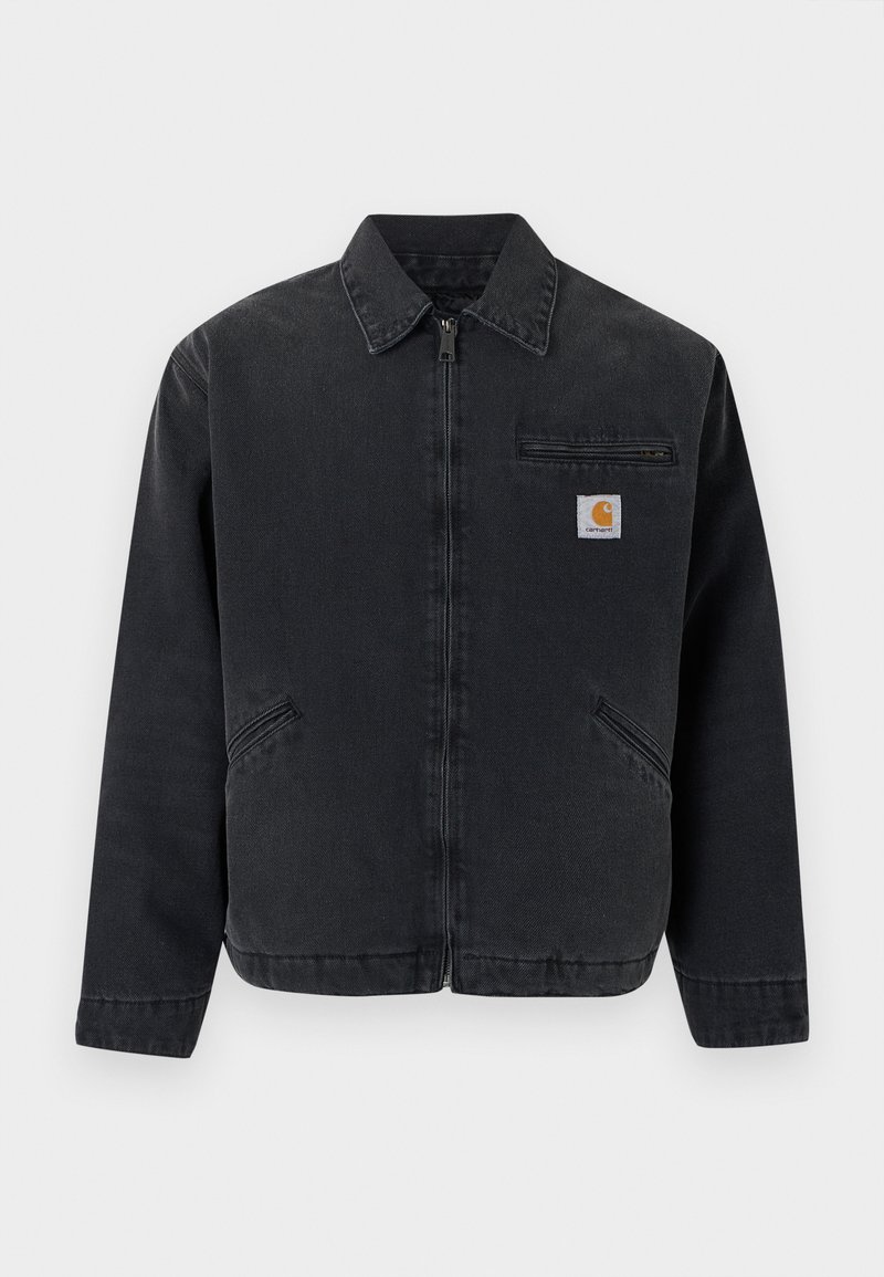 Giacca in denim scuro con cerniera frontale, collo a punta, due tasche laterali e una tasca sul petto con una toppa logo. Texture liscia.