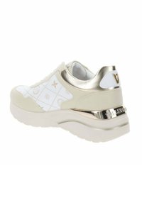 Zapatilla deportiva blanca con detalles y logotipos en dorado. Cuenta con una parte superior texturizada con un patrón geométrico y una suela gruesa de diseño distintivo.