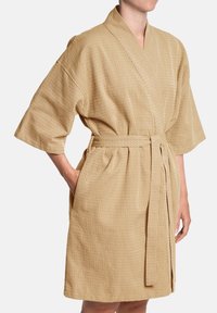 Béžový pruhovaný župan vyrobený z texturovanej látky s krátkymi rukávmi, s opaskom v páse a bočnými vreckami, s voľným strihom a dĺžkou po kolená.