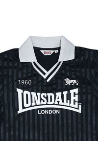 Μαύρο και γκρι ριγέ πουκάμισο Lonsdale London με λευκό γιακά, κείμενο 1960 και λιοντάρι λογότυπο στο στήθος.