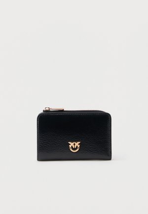 Portafoglio con zip in pelle nera testurizzata con emblema a forma di uccello in metallo dorato al centro sul davanti.