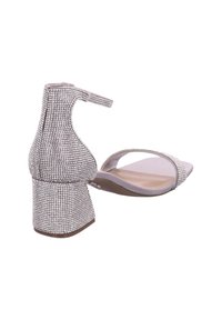 Sandalias de tacón plateado con un tacón grueso cubierto de rhinestones, punta abierta y correa en el tobillo. Plantilla suave y texturizada en un color claro.