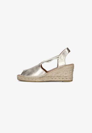 Metallic silver espadrille wedge with open toe, braided jute detail, and adjustable ankle strap. Smooth texture, rounded shape.