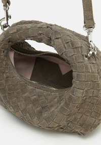 Borsa a tracolla in suede marrone con un design intrecciato e testurizzato. L'interno è foderato in tessuto rosa e presenta una tasca con zip. Accessori in metallo argentato.