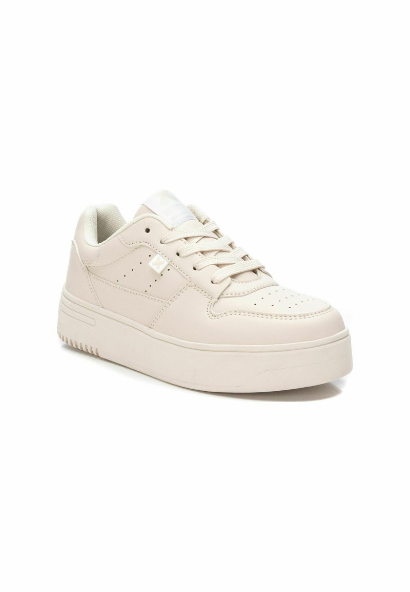 Baskets beige clair en cuir lisse, avec un bout arrondi, un design à lacets, des accents perforés et une semelle épaisse.