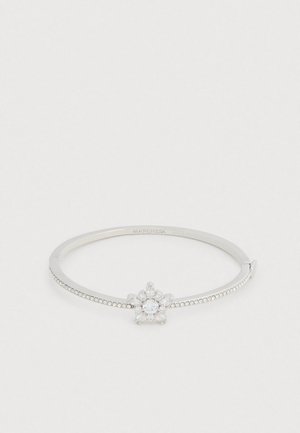 Sølv armring med en blomsterklynge af klare ædelstene i midten, med et tekstureret bånd og små cirkulære detaljer.