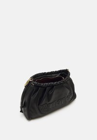 Clutch negro de Valentino con parte superior recogida, detalle de cadena dorada y logotipo en relieve en la parte frontal, mostrado ligeramente abierto sobre fondo blanco.