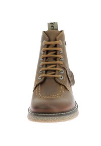 Bottine en cuir marron avec lacets et œillets en métal, bout rond, coutures contrastantes, semelle en caoutchouc et boucle à l'arrière.