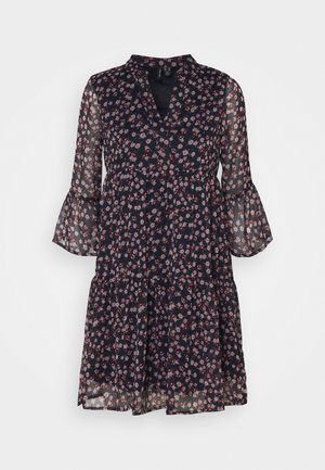 Laivastonsininen kukkamekko läpikuultavilla hihoilla, V-kaula-aukolla ja kerroksittaisella designilla. Koko mekossa on pieniä vaaleanpunaisia ja valkoisia kukkakuoseja.