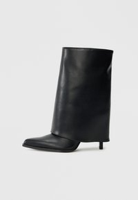 Μαύρο δερμάτινο μποτάκι αστραγάλου με δομημένο, διπλωτό σχέδιο, μυτερή μύτη και λεπτό τακούνι. Ομαλή υφή με ελάχιστες λεπτομέρειες.