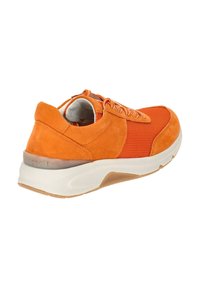 Oranje sneaker met een mix van suede en mesh, een gevoerde zool en contrasterende textuurpanelen. Inclusief witte accenten en veters.