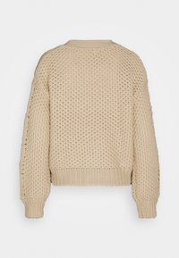 Beiger Strickpullover mit einem strukturierten Muster, gerippten Bündchen und einem gerippten Saum. Das Design umfasst einen runden Ausschnitt und überschnittene Schultern.