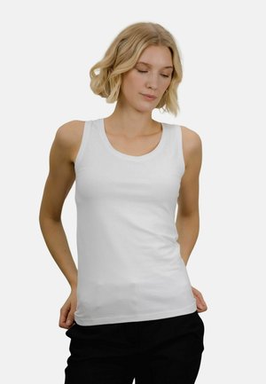 Hvit tank topp laget av bomull med en tettsittende design. Har en rund halsutskjæring og brede skulderstropper, og passer med svarte bukser.