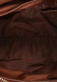 Fodera interna in tessuto marrone con una cerniera e dettagli di cucitura visibili all'interno di una borsa o di un sacchetto.