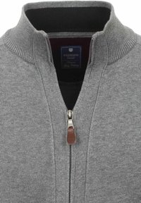 Grauer Reißverschluss-Pullover mit geripptem Kragen und Reißverschluss-Details. Verfügt über einen Leder-Reißverschlussanzug und ein inneres schwarzes Futter.