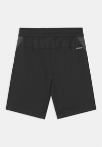 Zwarte sportieve shorts met een elastische tailleband, voorzien van een gestructureerd zijpaneel en een klein logo. Glad materiaal met een ademend ontwerp.