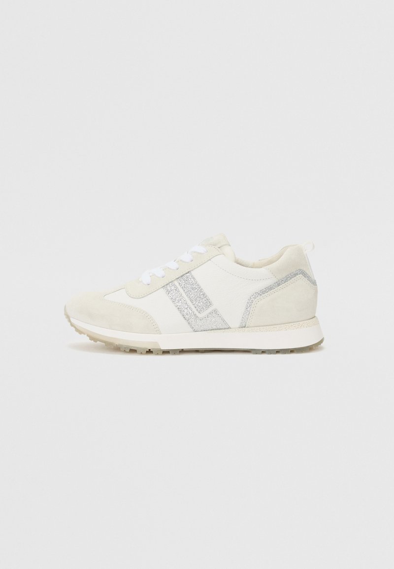 Hvit sneaker laget av semsket skinn og lær, med et sølvglitrende innslag, rund tå, flate lisser og en strukturert gummisåle.