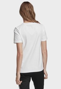 Witte katoenen T-shirt met korte mouwen, een ronde halslijn en een relaxte pasvorm. Soepele textuur, geen patronen of versieringen.