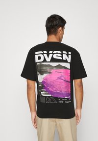 Black short-sleeve t-shirt featuring a large graphic print on the back with a pink and black landscape design and text.