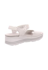 White platform sandals with a smooth leather upper, adjustable straps, cut-out design, and textured insole. Lightweight, featuring a ridged sole.