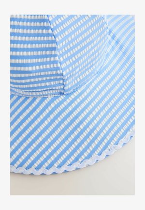 Prugasti šešir za sunce od svijetloplavog i bijelog materijala, s širokim obodom, teksturiranom površinom i dekorativnim valovitim rubom.