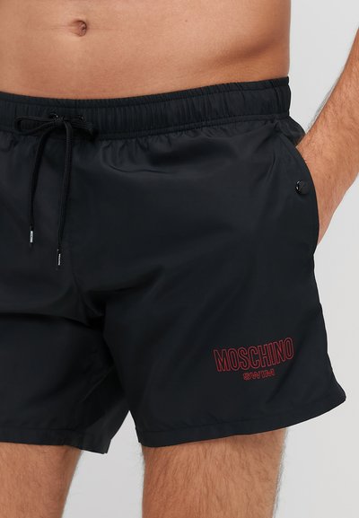 Boxeri de înot negri cu talie elastică, șnur și buzunare laterale. Prezintă logo-ul "MOSCHINO SWIM" în roșu pe partea stângă jos a piciorului.