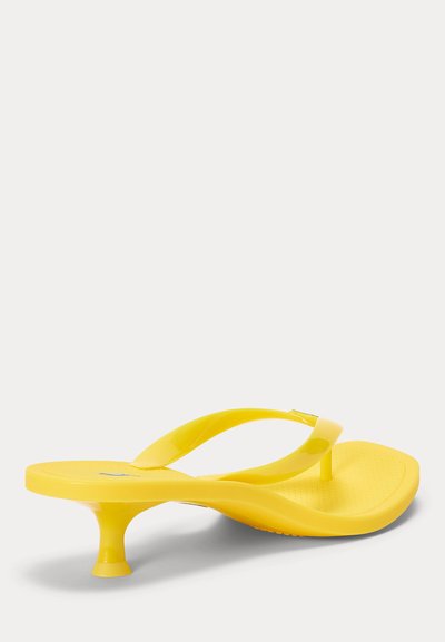 Sandale jaune brillante en tongs avec un petit talon kitten et une semelle texturée sur fond blanc.