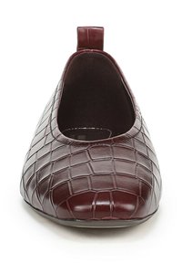 Chaussure plate en cuir bordeaux avec une texture crocodile, design à coupe basse et une languette à boucle à l'arrière pour un enfilage facile.