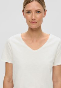 Witte katoen T-shirt met korte mouwen en een V-hals, met een gladde textuur en een minimalistisch ontwerp, geschikt voor casual gebruik.