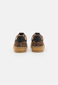 Leopardmönstrade sneakers med svarta accenter, textilmaterial, gummisålar och dragremmar vid hälen för enkel påtagning.