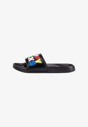 Black slide sandal featuring a textured strap with multicolored letters "HAPPY SOCKS." Flat sole, minimalist design, and smooth edges.
