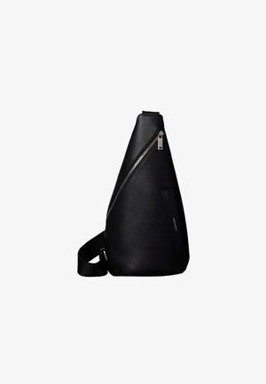 Sac à dos à bandoulière en cuir noir avec fermeture éclair diagonale argentée et sangle réglable, design minimaliste et texture lisse.