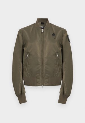 Oliivinvihreä bomber-takki, jossa edessä vetoketju, kaksi vetoketjullista taskua, resorit hihansuissa, helmassa ja kauluksessa sekä pienet mustat tarrat rinnassa ja hihassa.