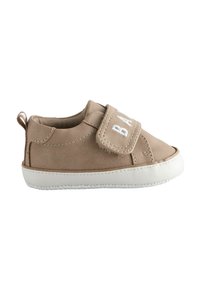 Beige lasten kengät, joissa on nubuck-pintakuvio, valkoinen kumipohja ja tarranauha, jossa on valkoisella kirjailtuna "BABY".