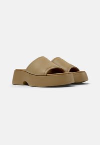 Infradito tan con punta aperta, realizzate in pelle liscia, con suola a piattaforma spessa e design arrotondato. Linee semplici e pulite.