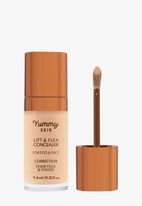 Lift & Flex Concealer in einer klaren Glasflasche mit beiger Nuance, gekrönt von einem glänzenden, bronzefarbenen Deckel. Enthält einen Applikator in Form eines Fußes.