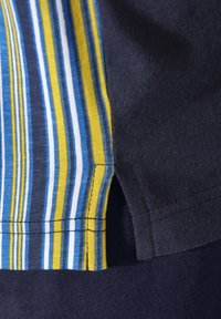 Striped fabric featuring blue, yellow, and white vertical lines on one side, contrasted with solid dark navy material. Visible stitching details.