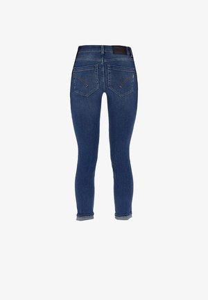 Jean skinny en denim bleu foncé. Les caractéristiques comprennent une taille haute, des poches arrière zippées et une couture subtile. Texture lisse avec un léger extensible.