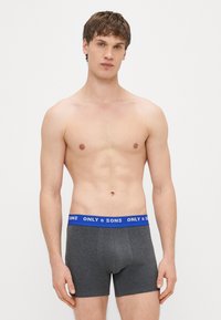 Ciemnoszare bokserki z niebieskim, elastycznym pasem w talii z logo "ONLY & SONS". Materiał wygląda na gładki, o dopasowanym kroju.