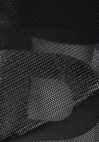 Tissu en mesh noir avec un motif texturé, présentant des degrés de transparence variables et un design fluide et superposé.