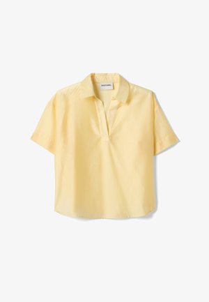 Kort mouwtjes, lichtgele blouse met open kraag en losse pasvorm, label "Stefanel" genaaid aan de binnenkant van de halslijn.